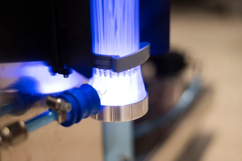 Lit light-guiding fibres fanning out of a steel collar